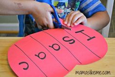 a child cutting out a name on a piece of paper