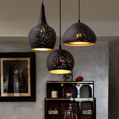 three lights hanging from the ceiling above a dining room table