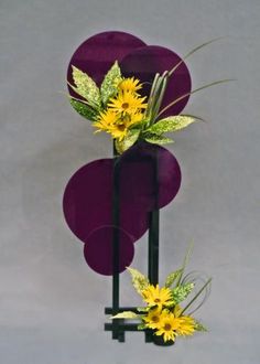 two purple vases with yellow flowers in them