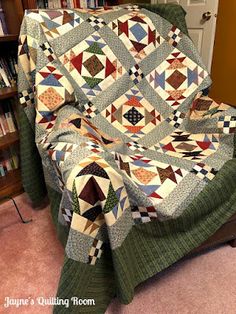 a chair with a quilt on it in front of a bookshelf