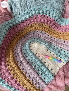 a crocheted blanket is laying on the floor