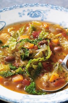 a bowl of soup with beans, broccoli and carrots