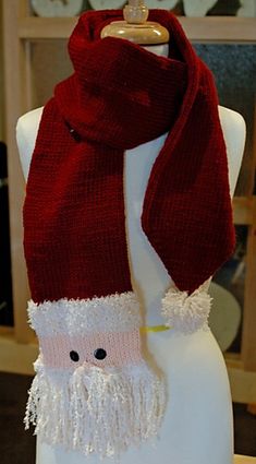 a knitted scarf with a santa claus face on it, sitting on a mannequin