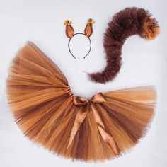 a brown tutu skirt and headband on a white background with an orange cat tail