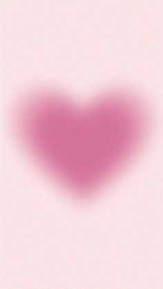 a blurry image of a red heart on a pink background with the word love written below it