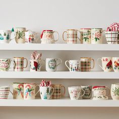 christmas mugs are lined up on the shelves