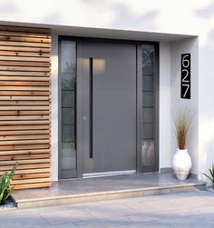 a modern entry door with glass panels and wood slats