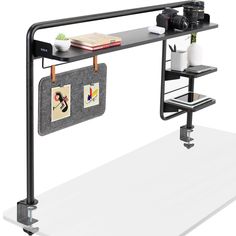 a black shelf with two pictures hanging from it's sides and a camera on the other side