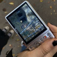 a person holding up a cell phone with a camera on it's display screen