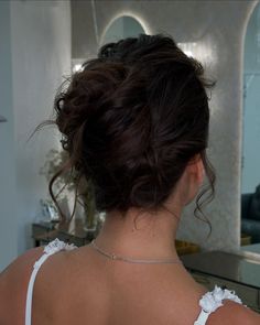 the back of a woman's head in front of a mirror