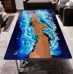 a coffee table with blue and brown paint on it in a living room area next to a couch