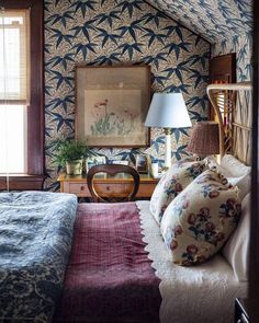 a bed room with a neatly made bed next to a window and a painting on the wall