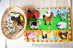 a wooden puzzle with farm animals on it next to a wicker basket filled with magnets