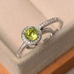 This ring features a 6 mm round cut natural peridot ,and sterling silver finished with rhodium. Customization is available. It is made by hand, and it will take about 7 days to finish the ring after your payment is completed. Main stone: natural peridot Main stone weight: Approx 0.96 ct Metal type: sterling silver finished with rhodium Accent stone: cz Customization is available, I also can make it with 14k solid gold (white or yellow or rose) and diamond accent stone, just feel free to contact Ruby Engagement Ring Vintage, Sterling Silver Halo Ring, Silver Halo Ring, Birthstone Engagement Rings, Vintage Engagement Rings Art Deco, August Birthstone Ring, Rose Gold Diamond Ring Engagement, White Sapphire Engagement Ring, Emerald Cut Rings