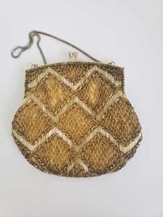 "Vintage gold beaded evening bag with diamond geometric design and kiss closure. There are two rhinestones accenting the closure. Hand made in Hong Kong for Du Val. The 14\" metal strap fits comfortable over the wrist or forearm. The lining is gold tone silky material.  The purse measures approximately 6 1/2\"by 6 3/4\" and the opening extends to 5\".  In very good condition with no missing beads and clean lining. Previously owned. There are subtle signs of age/use on the metal opening of the purse. Please see the photos as they are part of the description. Please do browse our other items as we do combine shipping for savings." Gold Rhinestone Clutch Fashion Accessory, Elegant Rectangular Bags With Gold Beads, Gold Beaded Bag For Events, Gold Beaded Bags For Events, Rectangular Gold Evening Bag, Elegant Rectangular Gold Beaded Bags, Elegant Wedding Bag With Gold Beads, Vintage Gold Pouch Shoulder Bag, Gold Beaded Pouch Bag