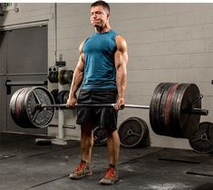 a man is holding a barbell in the gym