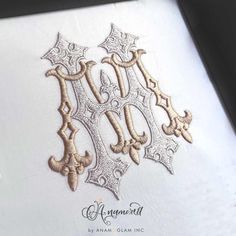 an embroidered monogram on the back of a white shirt with gold thread and sequins