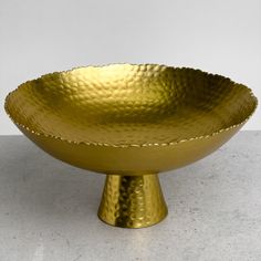 a golden bowl sitting on top of a table