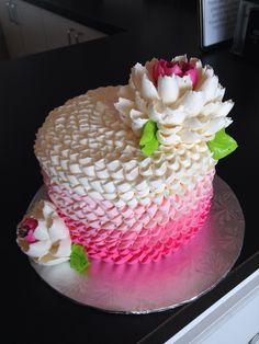 a cake with white and pink icing on a plate