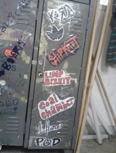 an old metal locker with graffiti on it's sides and some stickers on the doors