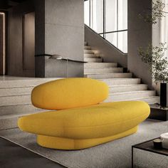 a yellow couch sitting on top of a carpeted floor next to a stair case