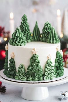 a green and white christmas cake with trees on it