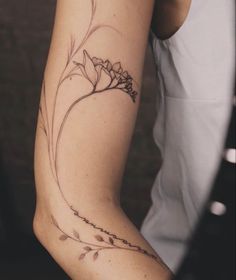 a woman's arm with a flower tattoo on the left side of her arm