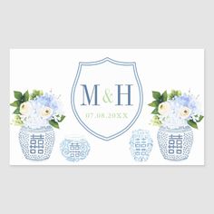 blue and white flowers in vases with the initial monogrammed on it's side