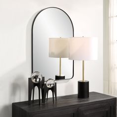 a table with a lamp and mirror on it