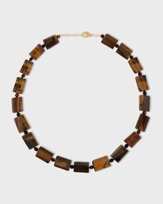 This stunning necklace features a polished tiger's eye stone suspended from a delicate 14k gold chain. The tiger's eye stone is known for its beautiful chatoyancy, which creates a mesmerizing play of light. This necklace is a unique and eye-catching piece that is perfect for everyday wear. Tigers Eye 14 Karat Gold 24 to 26 inches Handmade in NYC Elegant Brown Faceted Necklace, Yellow Gold Agate Necklace With Gemstones, Gold Rectangular Gemstone Beads Jewelry, Rectangular Gemstone Beads Gold Jewelry, Gold Rectangular Jewelry With Gemstone Beads, Rectangular Gold Jewelry With Gemstone Beads, Brown Faceted Jewelry Gift, Brown Gemstone Pendant Necklace, Gold Rectangular Necklaces With Natural Stones