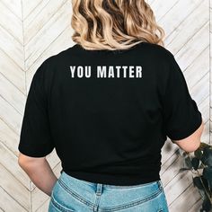 YOU MATTER Shirt with "You Matter" written on the front and back Unisex 100% cotton making shirt super soft, comfortable and lightweight. Runs true to size Machine wash inside out in cold water Questions?  Contact me, I want to hear from you. Concerns? Kindly reach out to me so I can make things right!  Thank You for choosing MADesigns! Meaningful Text Print Crew Neck Tops, Inspirational Black Short Sleeve T-shirt, Inspirational Black Relaxed Fit T-shirt, Inspirational Black Tops With Text Print, Inspirational Black Pre-shrunk Top, Inspirational Text Print Black Tops, Inspirational Crew Neck Top With Funny Text, Custom Text Short Sleeve Tops For Streetwear, Short Sleeve Tops With Custom Text For Streetwear