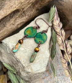 These lightweight earrings are made with a 4mm Tiger's Eye, and an Arizona Turquoise stick chip, which hangs from a turquoise patinated copper disc. They are hung on antique copper ear wires. The earrings are about 1-7/8" long from the top of the earring wire to the bottom of the beaded dangle, and are approximately 1/2" wide. These are fun earrings that go well with casual wear or semi-formal wear, and have great summer vibes! Each pair of earrings is shipped inside of a nice gift box ready for gift giving or to enjoy for yourself. All my jewelry is hand crafted so that when you wear it, you will know that you are wearing something that is truly natural and unique. If you are looking for an earring that is either shorter, or longer, or perhaps for a matching necklace, please take a look a Green Electroformed Bohemian Jewelry, Green Bohemian Electroformed Jewelry, Bohemian Green Electroformed Jewelry, Adjustable Bohemian Patina Earrings, Bohemian Hypoallergenic Bronze Earrings, Bohemian Bronze Hypoallergenic Earrings, Hypoallergenic Bohemian Bronze Earrings, Bohemian Green Jewelry With Patina, Green Rustic Dangle Earrings