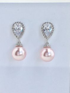 Classic cubic zirconia and pearl bridal earrings in rhodium plated brass setting. Earrings feature teardrop clear cubic zirconia ear post and 10mm Swarovski rosaline pink pearl dangle drop. Total length of the earrings is 2.7 cms. For match necklace click: https://www.etsy.com/listing/514758984/pink-pearl-necklace-blush-pink-bridal?ref=listing-shop-header-3 For complete set click: https://www.etsy.com/listing/528565041/rose-bridal-pearl-set-blush-pink-crystal?ref=listing-shop-header-2 To browse Elegant Pink Cubic Zirconia Bridal Earrings, Elegant Pink Sterling Silver Bridal Earrings, Pink Pearl Earrings For Formal Occasions, Formal Pink Pearl Earrings, Elegant Pink Sterling Silver Pearl Earrings, Elegant Pink Pearl Earrings In Sterling Silver, Pink Pearl Drop Bridal Earrings For Wedding, Pink Pearl Drop Earrings For Wedding, Elegant Pink Teardrop Pearl Earrings