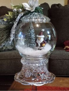 a snow globe with santa clause in it sitting on a coffee table next to a couch