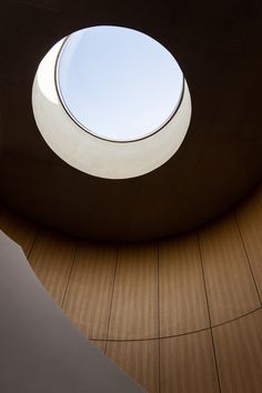 a round window is shown in the center of a room with wood flooring and walls