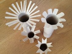 three vases made out of toilet paper on a wooden table with holes in them