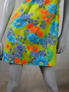 This 1970s vintage Hawaiian dress has a stunning floral pattern in blue, orange, and yellow on a green background. The sleeveless cotton summer dress has a slight scoop neckline, a relaxed-fit waistline, inverted pleats on both sides of the front, an inner back-tie so that you can fit the dress to be show your form. An 11-inch (27.94cm)zipper in the back makes dressing an ease. Size 8 US, 12 UK Bust = 36 inches (91cm) Waist = 37 inches (93.98cm), with inner tie-back if you want a more fitted look Hips = 42 inches (106.68cm) Dress Length = 35 inches (88.9cm)  Brand label: Noelani Casuals (Made in Hawaii) Material: Cotton Condition: Excellent (Professionally Cleaned ... soft and supple, with no stains, tears, wear spots, or weaknesses in the seams)   --- DESCRIPTION ASSURANCE --- I want you Hawaiian Vintage, Vintage Hawaiian Dress, Cotton Summer Dress, Vintage Tropical, Cotton Dress Summer, Hawaiian Dress, Brand Label, Vintage Hawaiian, Sleeveless Floral Dress