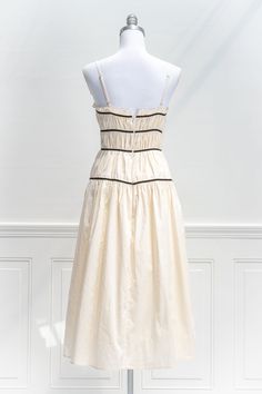 Reminiscent of the elegant summer silhouettes of the 50s and 60s, the Roman Holiday Dress in crisp cream cotton features adjustable spaghetti straps, side-seam pockets, an a-line skirt, and lovely black velvet ribbon piping details. . Details: S: Bust: 32"-34", Waist 24"-26", Length: 47" M: Bust 34"-36", Waist 26"-28", Length: 48" L: Bust 36"-38", Waist 28"-30", Length: 49" Runs Small, Please Check the Measurements Skirt Length Waist to Hem: 30" Lined Material: 100% Cotton Lining: 100% Rayon Han