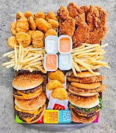 a tray filled with lots of different types of food next to french fries and chicken nuggets