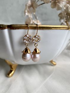 A classic pair of earrings with a soft blush freshwater pearl, brass embellishments, and finished with a sparkly pave ear hook that is gold finished sterling silver. Limited supply available. Shipping and Production Time All Erin Rhyne pieces are made to order. Please allow 3-4 weeks for your order to be made and shipped. Shipping time is not accounted for in the 3-4 weeks of production, so please plan accordingly — all pieces ship free UPS ground in the United States. Rush shipping/production i Elegant Pearl Earrings With French Hook For Wedding, Pearl Earrings With French Hook For Wedding, Elegant Pink Earrings With French Hook, Gold Hooks, Ear Hook, Gold Finish, Fresh Water, Freshwater Pearls, Rush