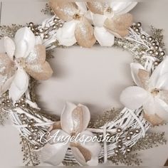 a white and gold wreath with flowers on it