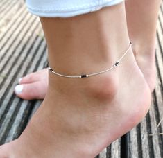 "This minimalist ultra thin anklet is perfect for bridesmaid or as wedding jewels. It's one minimalist ultra thin anklet made with sterling silver snake chain adorned with black miyuki beads. (you can choose your beads color and select it in the drop down menu) ➵ Perfect to wear alone or for layering with more bracelets. ➵ More Anklets : https://www.etsy.com/fr/shop/silverbirdjewels?ref=seller-platform-mcnav&section_id=21837916 --*--*--*--*--*--*--*--*--*--*--*--*--*--*--*--*--*--*-- ∞ SIZE ∞ - Length: Adjustable bracelet - around 20 cm (7,9 in) - 25 cm (9,8 in). If you like another length please make a note when you \"check out\" (I can make it for children) . ∞ MATERIAL ∞ - Sterling silver: All the silverbird jewels are made with 925 Sterling silver who is an alloy of silver, which consi Black Silver Anklets, Silver Black Beads Anklets, Silver Anklet With Black Beads, Anklet Designs Silver, Ankle Beads, Payal Designs Silver, Anklet Design, Black Anklet, Silver Chain Anklet