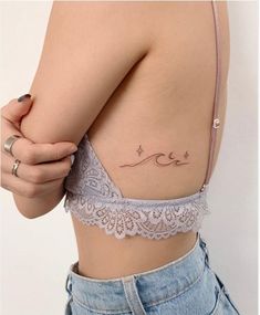 a woman with a tattoo on her stomach and the word love written in cursive writing