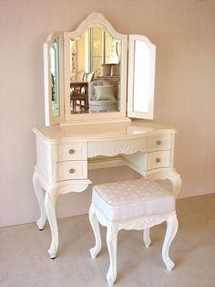 a white dressing table with mirror and stool