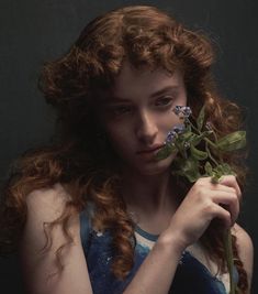 a woman holding a flower in her hand