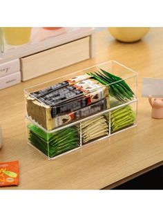 a clear plastic container filled with lots of different types of food on top of a wooden table