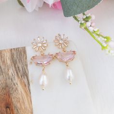 "These floral earrings features gold crystal daisy posts with pink stones and pearl drops.  A perfect bridal earrings for your wedding festivities such as bridal shower, rehearsal dinner or to elevate your wedding guest style. ✨Suggested occasion for wear: wedding guest, Sunday Brunch, bridal shower, Summer picnic Details : ----------- - gold plated flower with sterling silver posts - freshwater pearls - light pink crystal stones - lead & nickel free Dimension --------------- Earrings : 5/8 inch Feminine Pink Pearl Drop Earrings, Feminine Pearl Drop Flower Earrings, Rose Gold Flower Earrings With Pearl Drop, Rose Gold Flower-shaped Earrings With Pearl Drop, Elegant Pink Teardrop Flower Earrings, Feminine Flower Drop Earrings With Pearl Drop, Pink Feminine Dangle Pearl Earrings, Feminine Flower Dangle Earrings With Pearl Drop, Feminine Pearl Flower Earrings