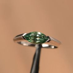 It is a green sapphire ring. The main stone is 5 mm*10 mm marquise cut.weight about 1.34 carats.The basic metal is sterling silver and plated with rhodium/14k white  gold/14k rose gold/14k yellow goldYou can also go to my shop Home for more elegant rings: https://www.etsy.com/shop/godjewelry?ref=hdr_shop_menu Customization is always welcome and please feel free to contact with me if you have any design ideas! Wedding Ring Marquise, Elegant Rings, Solitaire Wedding Ring, Twig Engagement Ring, Green Sapphire Ring, Gemstone Wedding Rings, Sapphire Wedding Rings, September Birthstone Rings, Blue Gemstone Rings