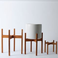 three wooden chairs and one white planter