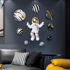 a living room filled with furniture and wall art on the walls, including an astronaut clock